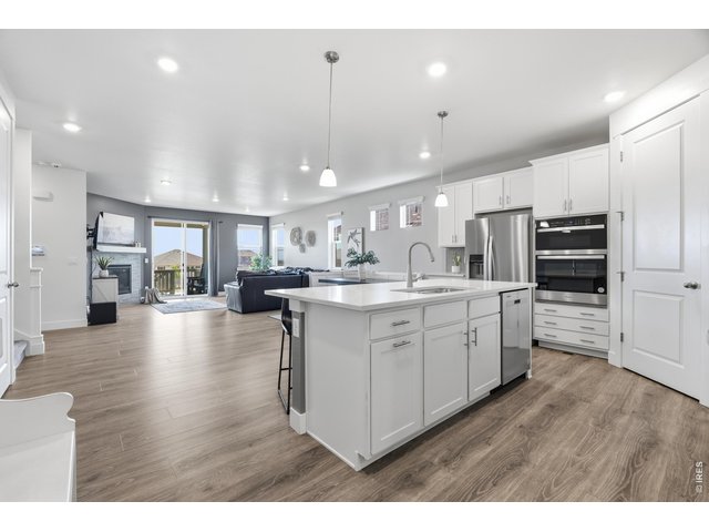 Property Photo 7 The kitchen's quartz island anchors an open floor plan that flows steamlessly into the living room.