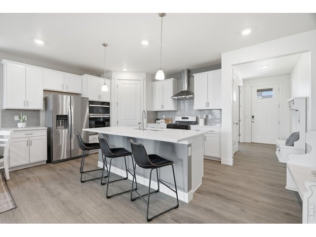 Property Photo 4 The large chef's kitchen features quartz counters with plenty of natural light and prep space.