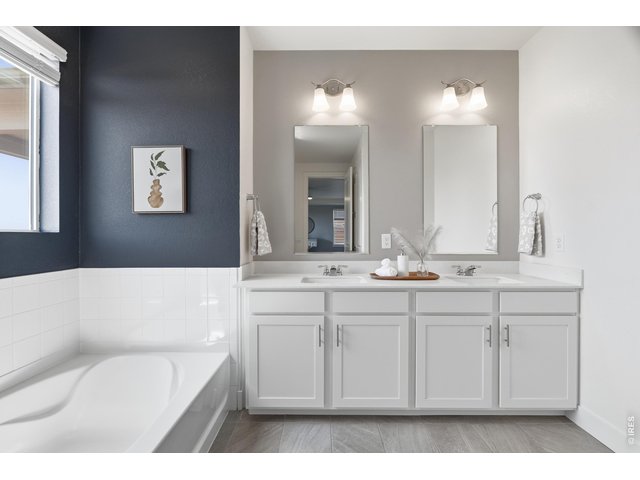 Property Photo 19 The large primary bathroom features quartz counters and double sinks.