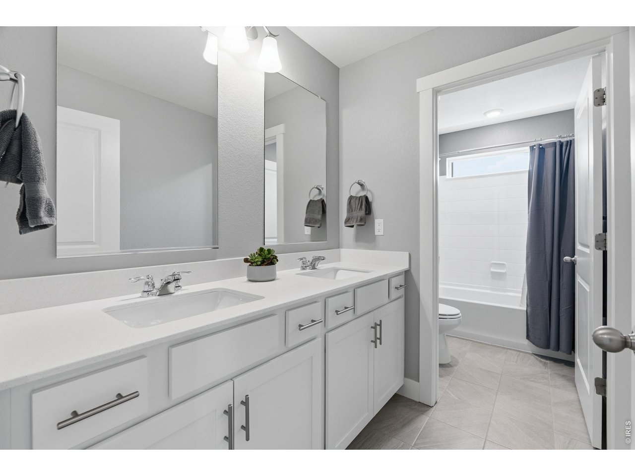 Property Photo 28 Shared bathroom on upper level with double vanity and privacy door.