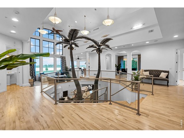 Property Photo 9 Dramatic open-concept design with soaring ceilings, glass railings and signature indoor palm trees.
