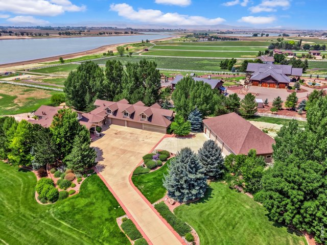 Property Photo 6 Expansive estate setting with beautifully landscaped grounds and sweeping reservoir and Front Range views. Aerial view of the property and surrounding reservoir. Grass color has been enhanced in professional photography.