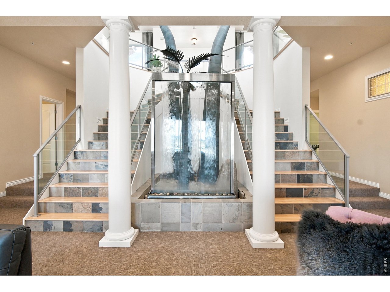Property Photo 24 Showstopping water feature framed by dual staircases, glass railings and architectural columns.