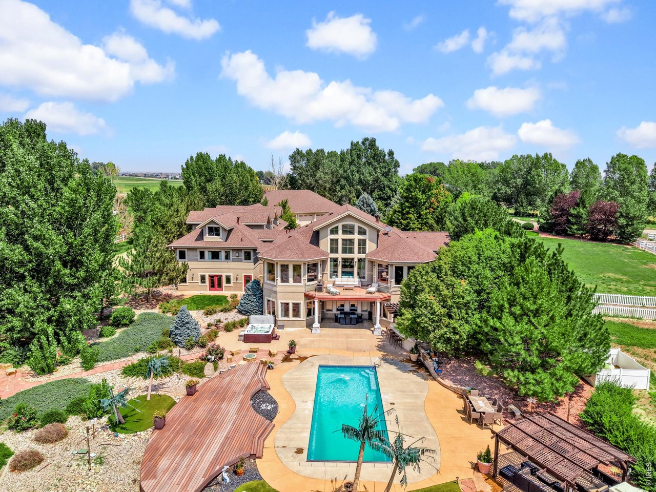 Property Photo 3 Resort-inspired backyard featuring a swimming pool, hot tub, putting green, multiple outdoor entertaining areas and lush landscaping.