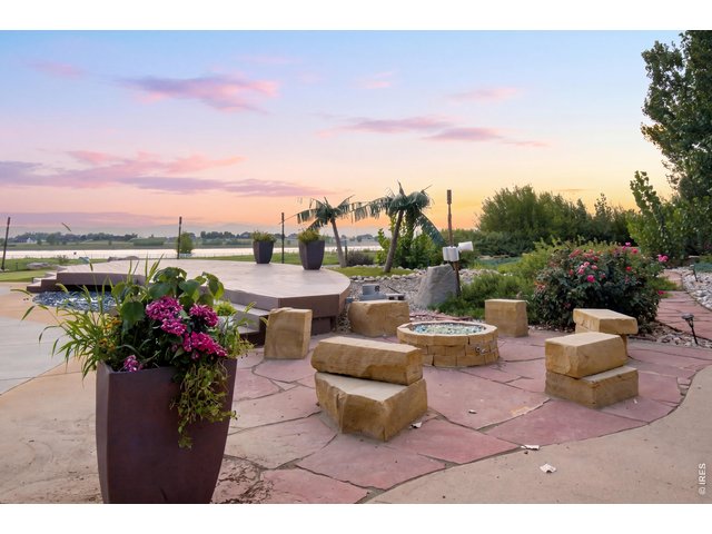 Property Photo 45 Custom fire pit seating area surrounded by mature landscaping with beautiful sunset and water views.