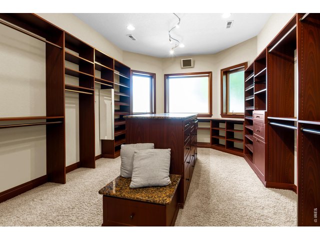 Property Photo 22 Exceptional custom walk-in closet with extensive built-in cabinetry, shelving, center island and natural light.