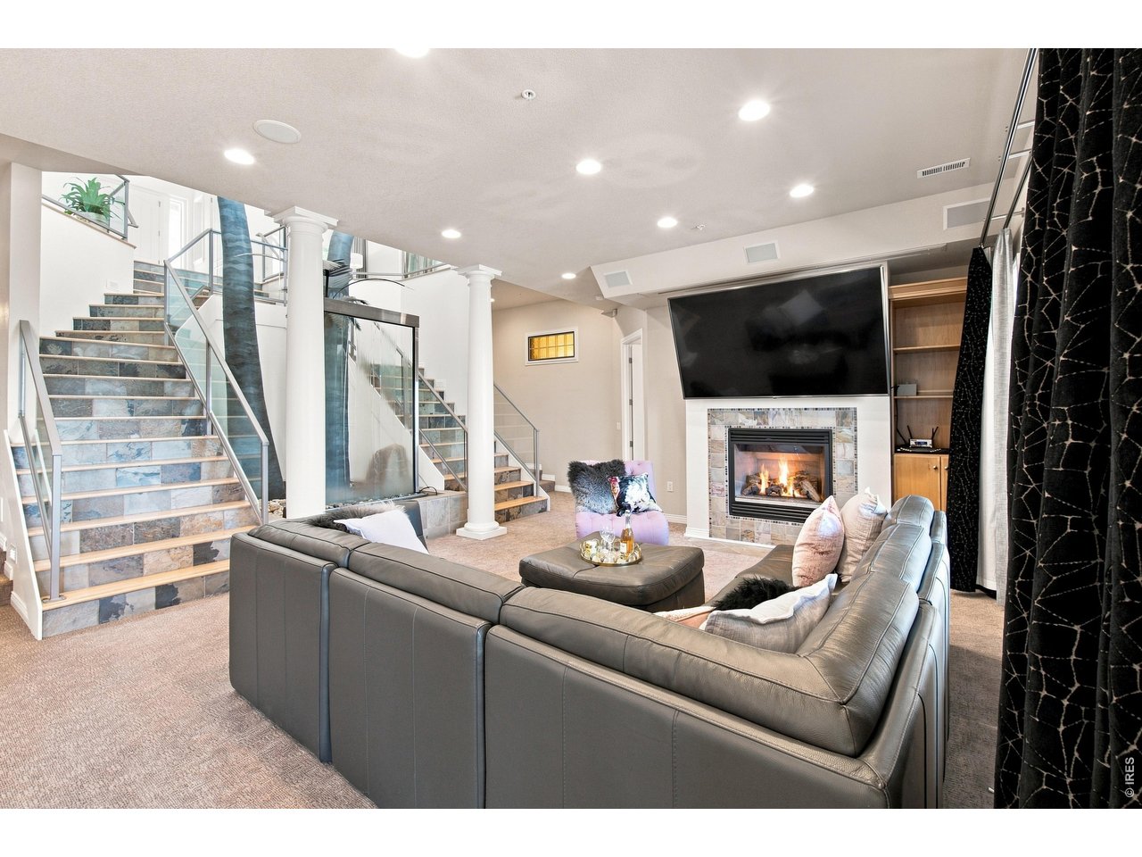 Property Photo 27 Lower-level family room with fireplace, built-in entertainment area and dramatic architectural details.