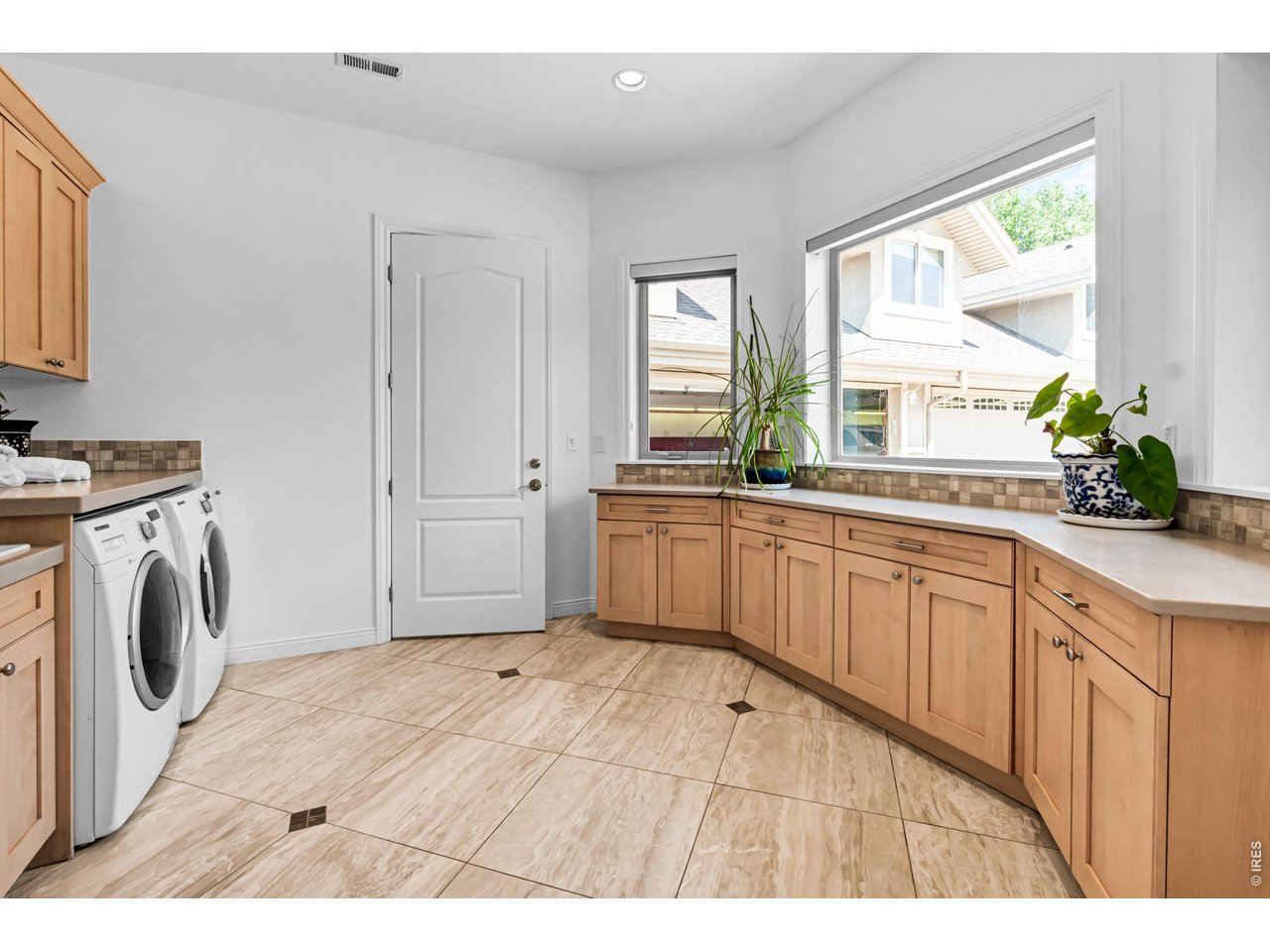 Property Photo 41 Oversized laundry room with extensive cabinetry, counter space, utility sink area and abundant natural light.