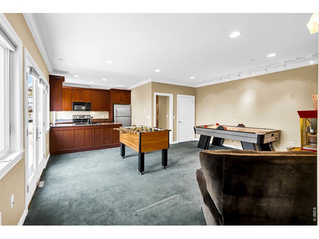 Property Photo 37 Spacious bonus room ideal for a home office, game room or additional living space, complete with kitchenette and abundant natural light.