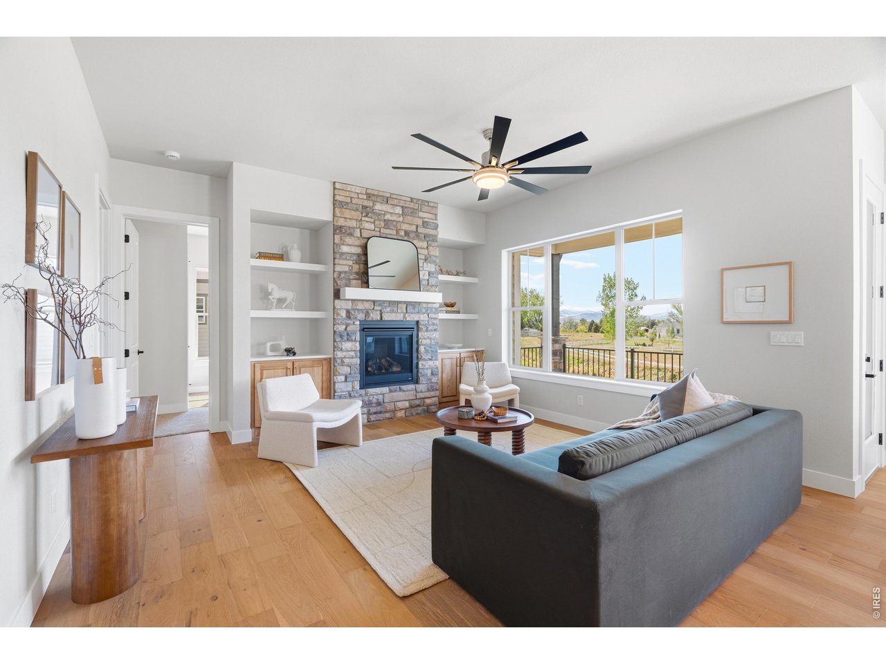 Property Photo 11 Light-filled living room with large windows framing open space and mountain views.