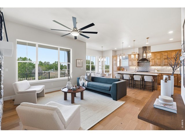 Property Photo 5 Light-filled living room with large windows framing open space and mountain views.