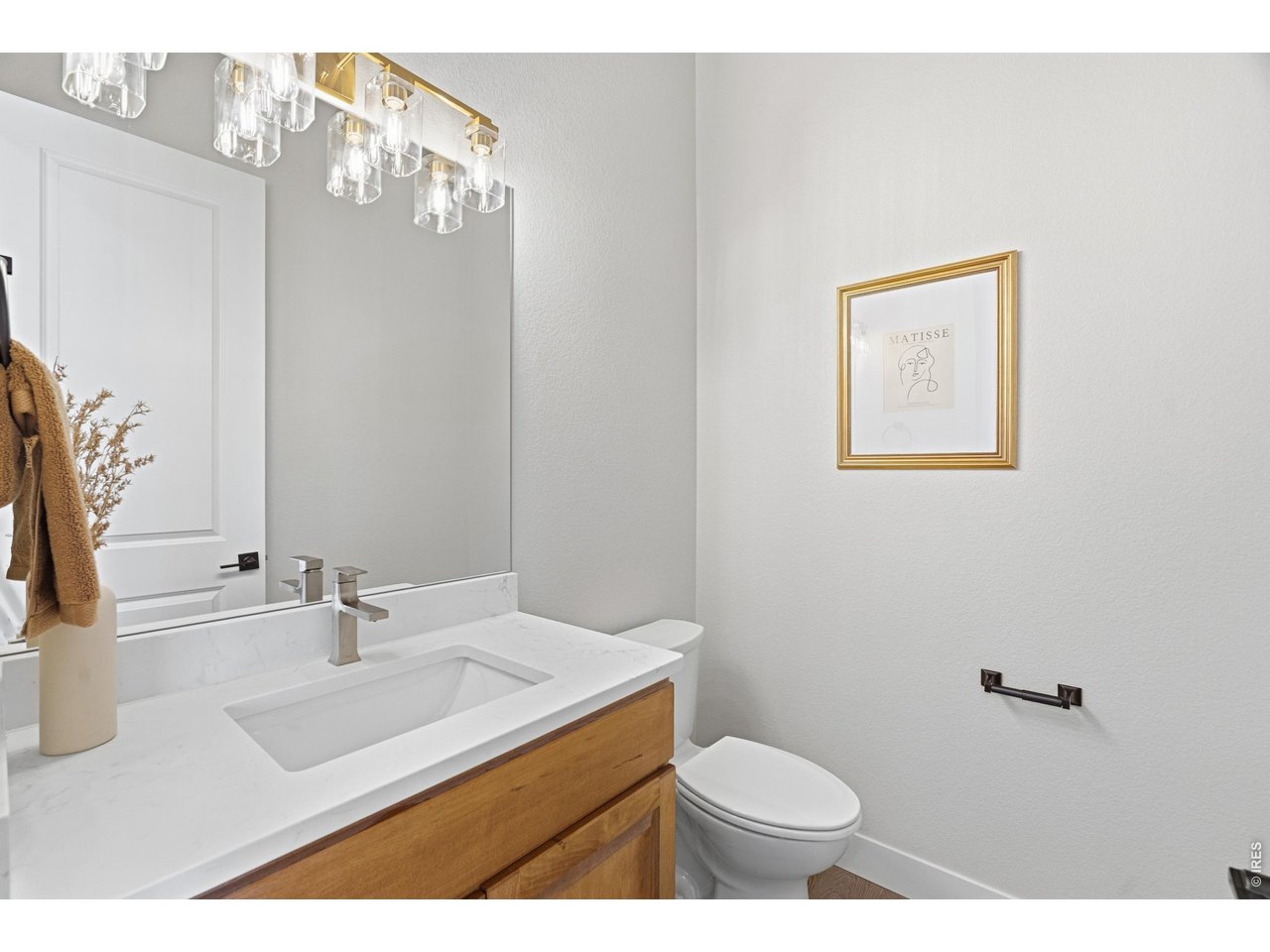 Property Photo 19 Main-level powder bath with quartz countertops and modern lighting.