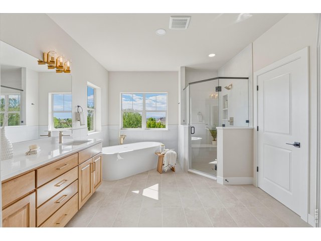 Property Photo 23 Spa-inspired primary bath featuring a freestanding soaking tub, oversized glass shower, and dual vanities.