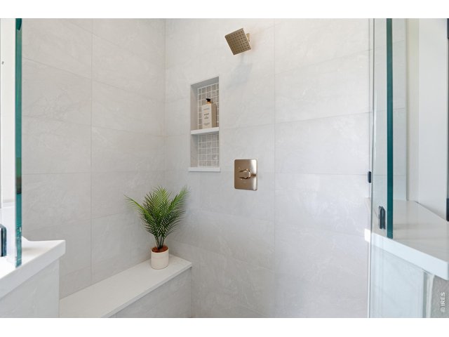 Property Photo 25 Oversized walk-in shower with modern tilework and built-in niche.
