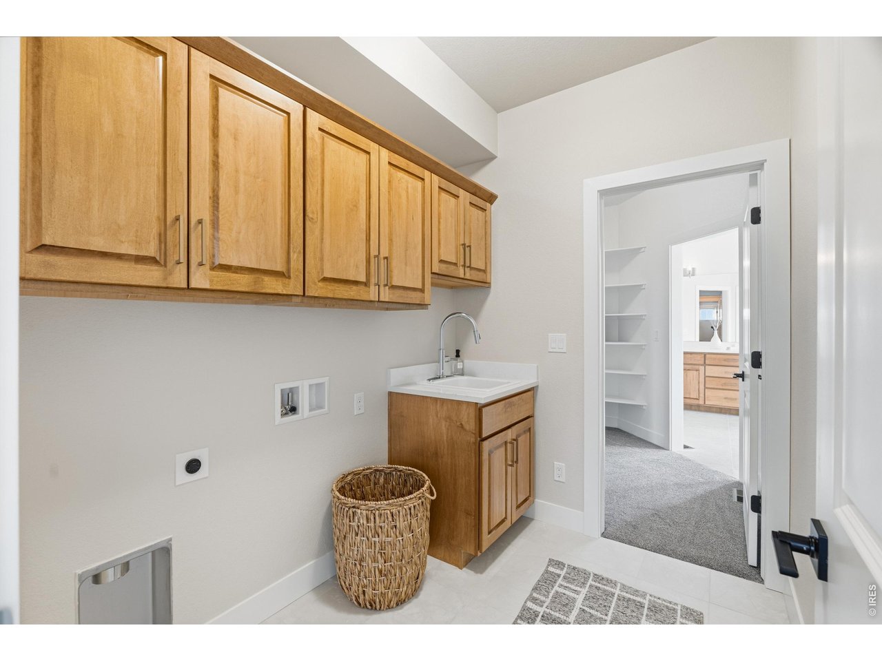 Property Photo 28 Well-appointed laundry room with upper cabinetry, utility sink, and functional layout connecting to primary closet.