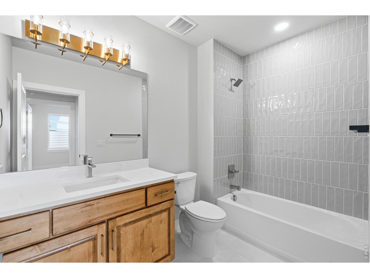 Property Photo 39 Full bathroom basement - crisp and bright with quartz countertops, warm wood cabinetry.