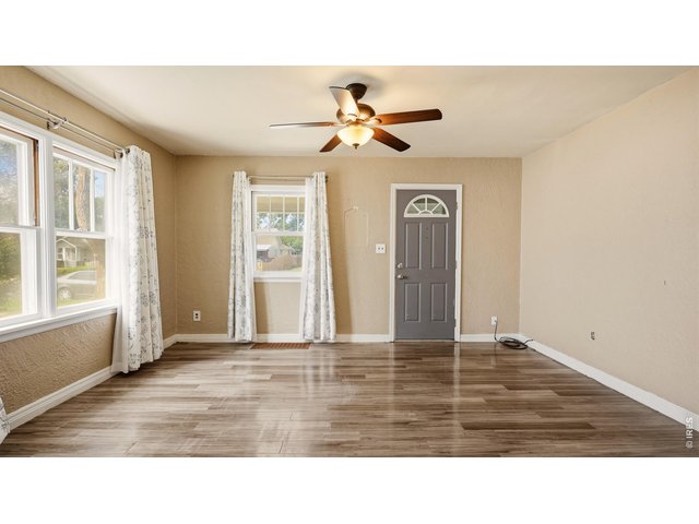 Property Photo 4 Bright living room with multiple windows and LVP flooring.