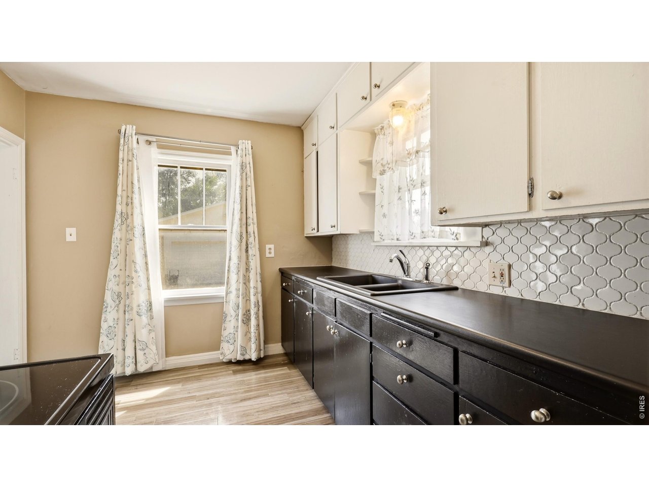 Property Photo 9 Kitchen with ample cabinetry, counter space and decorative backsplash.