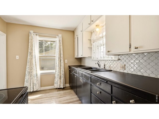 Property Photo 9 Kitchen with ample cabinetry, counter space and decorative backsplash.