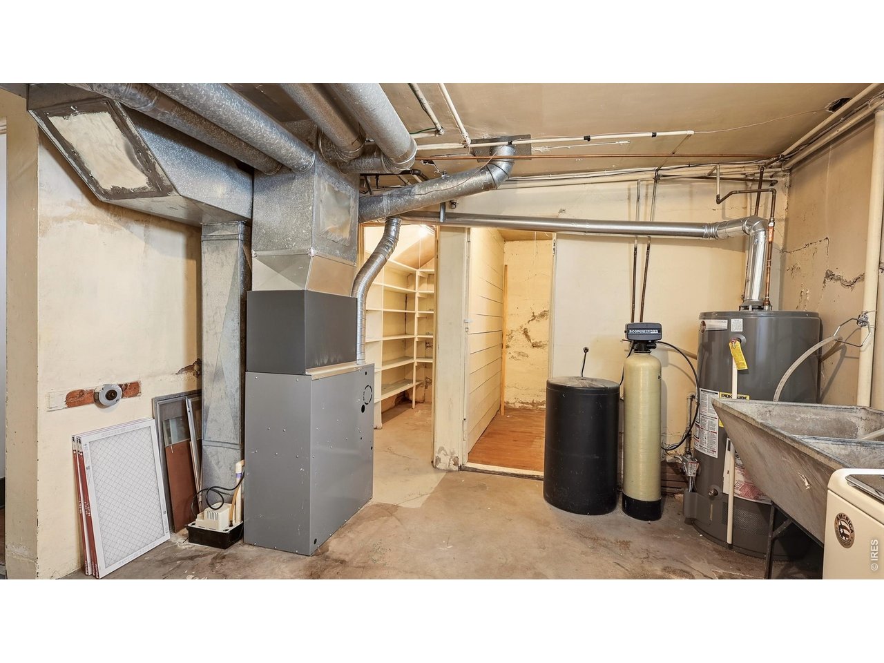 Property Photo 21 Additional view of the basement utility area with furnace, water heater, and storage space.