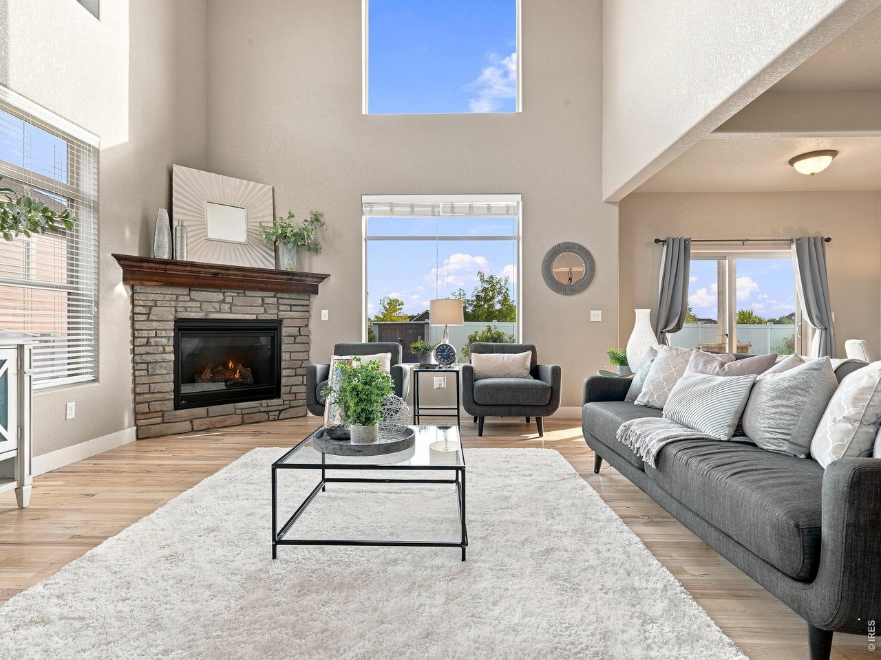 Property Photo 8 Elegant main living room filled with natural light from dramatic two-story windows.