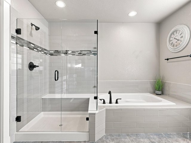 Property Photo 24 Large walk-in shower featuring built-in bench seating. Relax in the oversized soaking tub after a long day.