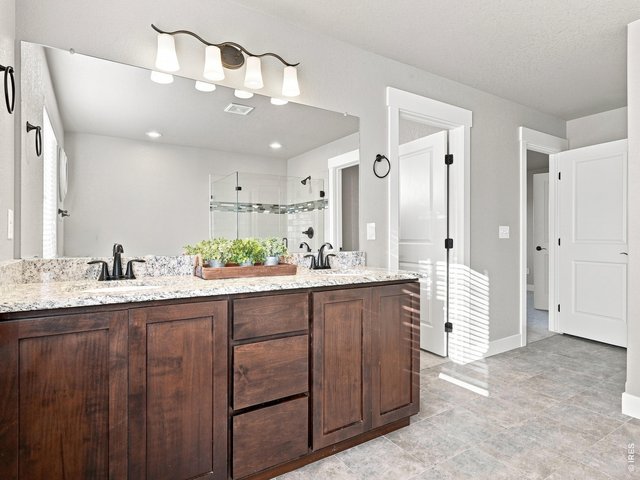 Property Photo 25 Primary bathroom with dual vanities and abundant cabinet storage.