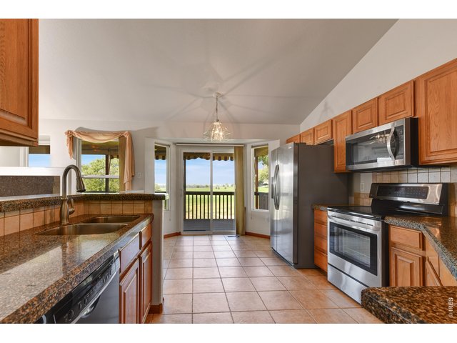 Property Photo 6 Kitchen with tile floor - granite counter tops doors and windows to the covered deck