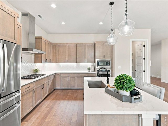 Property Photo 3 The gourmet kitchen is truly the heart of the home. Under-cabinet lighting creates both function and ambiance. Upgraded stainless steel appliances complete this chef-inspired kitchen.