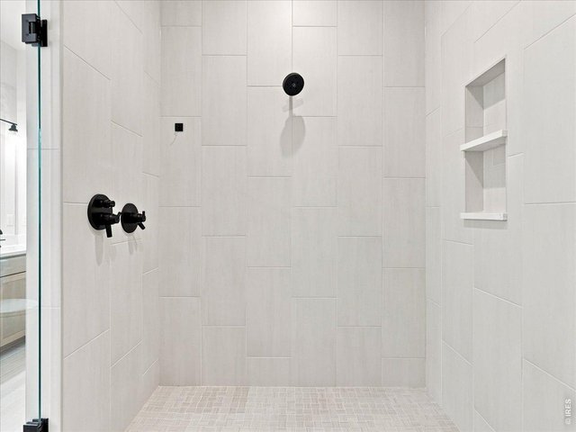 Property Photo 23 Oversized walk-in shower features dual shower heads plus a handheld upgrade.