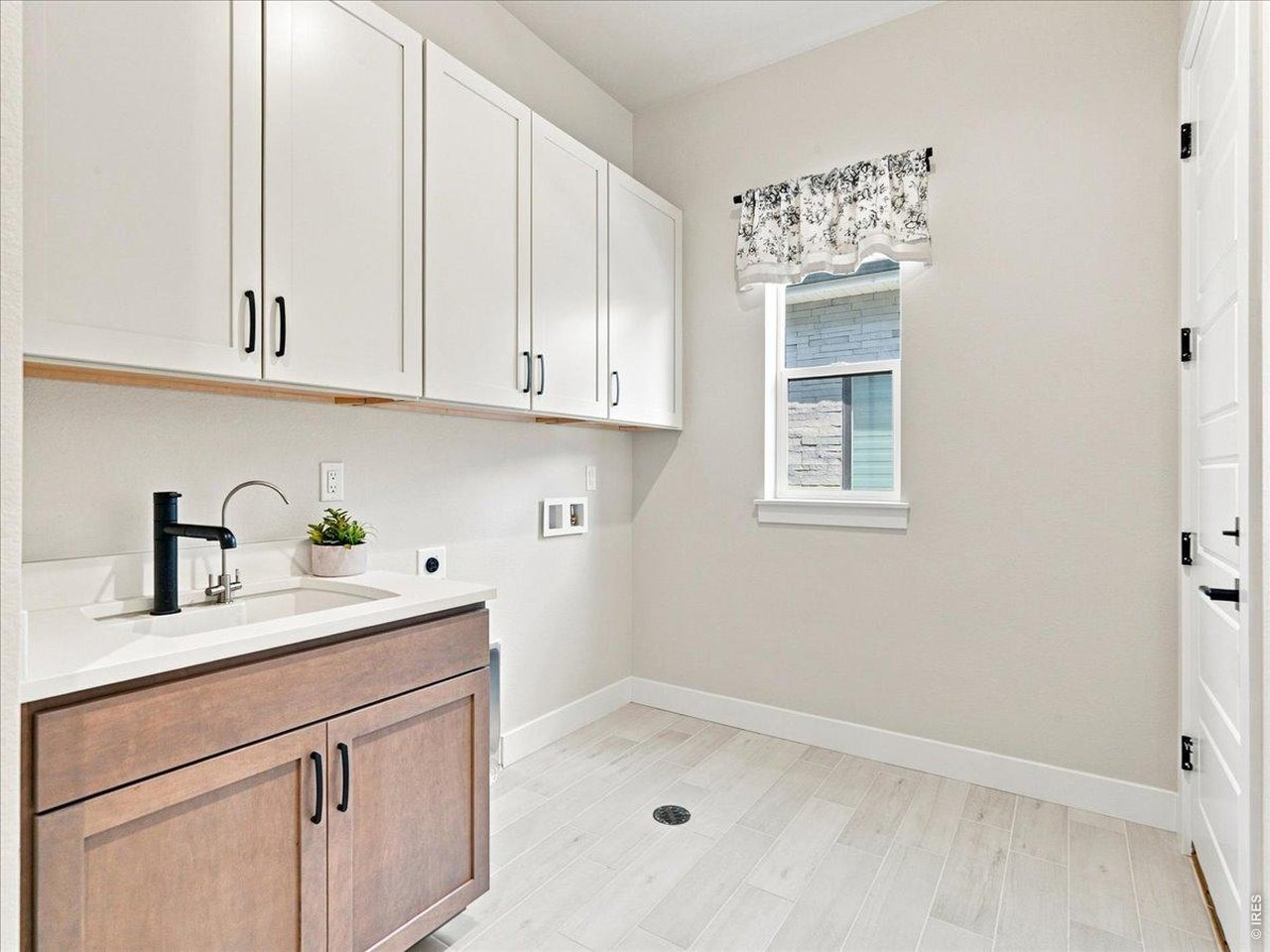 Property Photo 43 Well-appointed laundry room features quartz countertops and utility sink. Added upper cabinetry offers abundant storage.