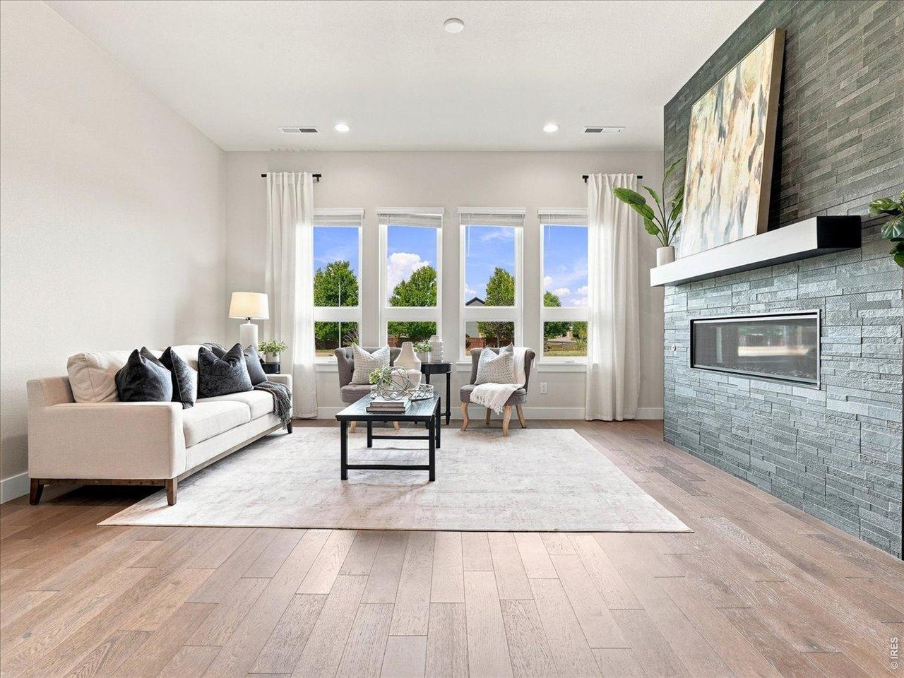 Property Photo 4 The great room features soaring natural light and a warm, inviting fireplace.