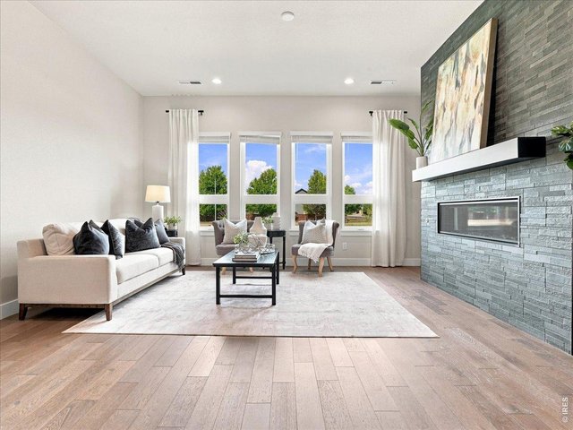 Property Photo 4 The great room features soaring natural light and a warm, inviting fireplace.