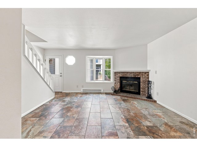 Property Photo 8 Bright and inviting living room featuring a wood-burning fireplace, abundant natural light, and a fresh, move-in-ready feel.