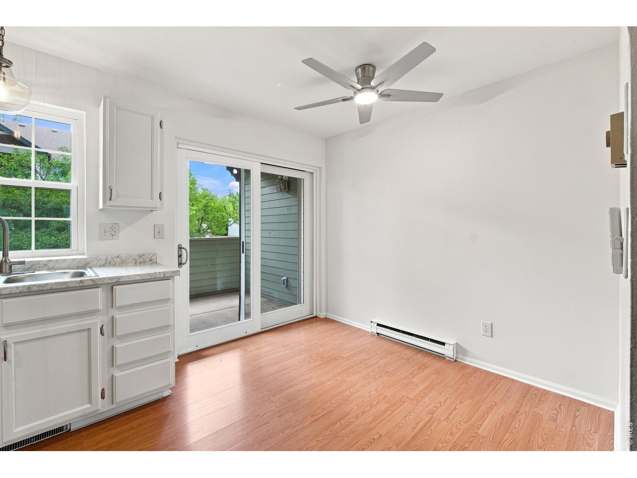 Property Photo 2 Light-filled dining area with updated ceiling fan and direct access to the private outdoor deck.