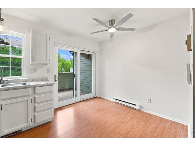 Property Photo 2 Light-filled dining area with updated ceiling fan and direct access to the private outdoor deck.