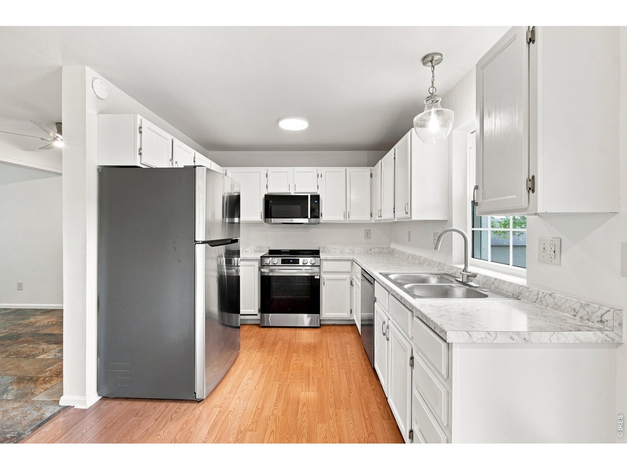 Property Photo 1 Freshly updated kitchen featuring new countertops and backsplash, stainless-steel sink and faucet, and bright white cabinetry.