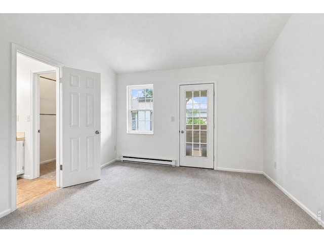 Property Photo 17 Spacious bedroom with new carpet, fresh paint and private deck access.
