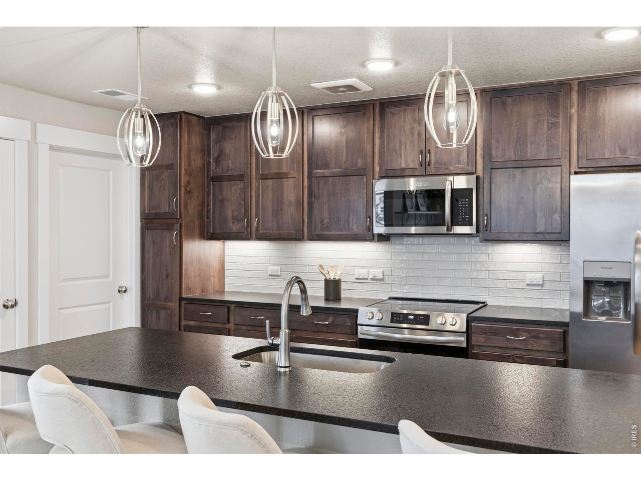 Property Photo 9 Huge breakfast bar provides an expansive workspace, complemented by stylish drop-down lighting that enhances the overall ambiance.