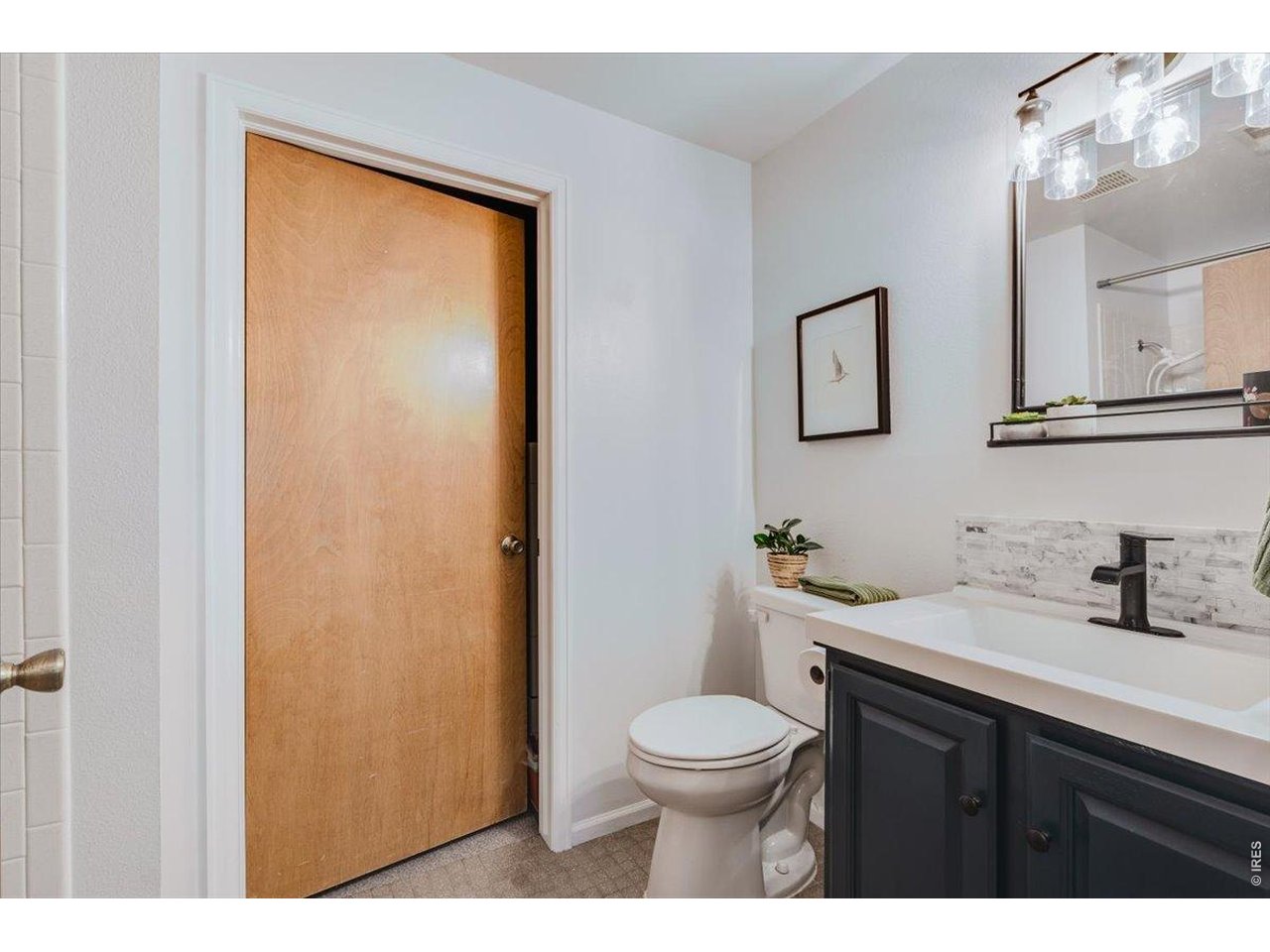 Property Photo 36 3rd bathroom is in the lower level with a shower, the door opens to the laundry/storage room