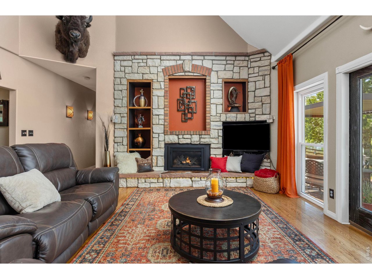 Property Photo 33 Stone fireplace anchors the living room while windows and doors connect the interior to the waterfront setting.