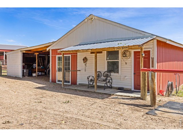 Property Photo 27 Functional barn interior with covered aisle, stalls and space for hay and equipment.