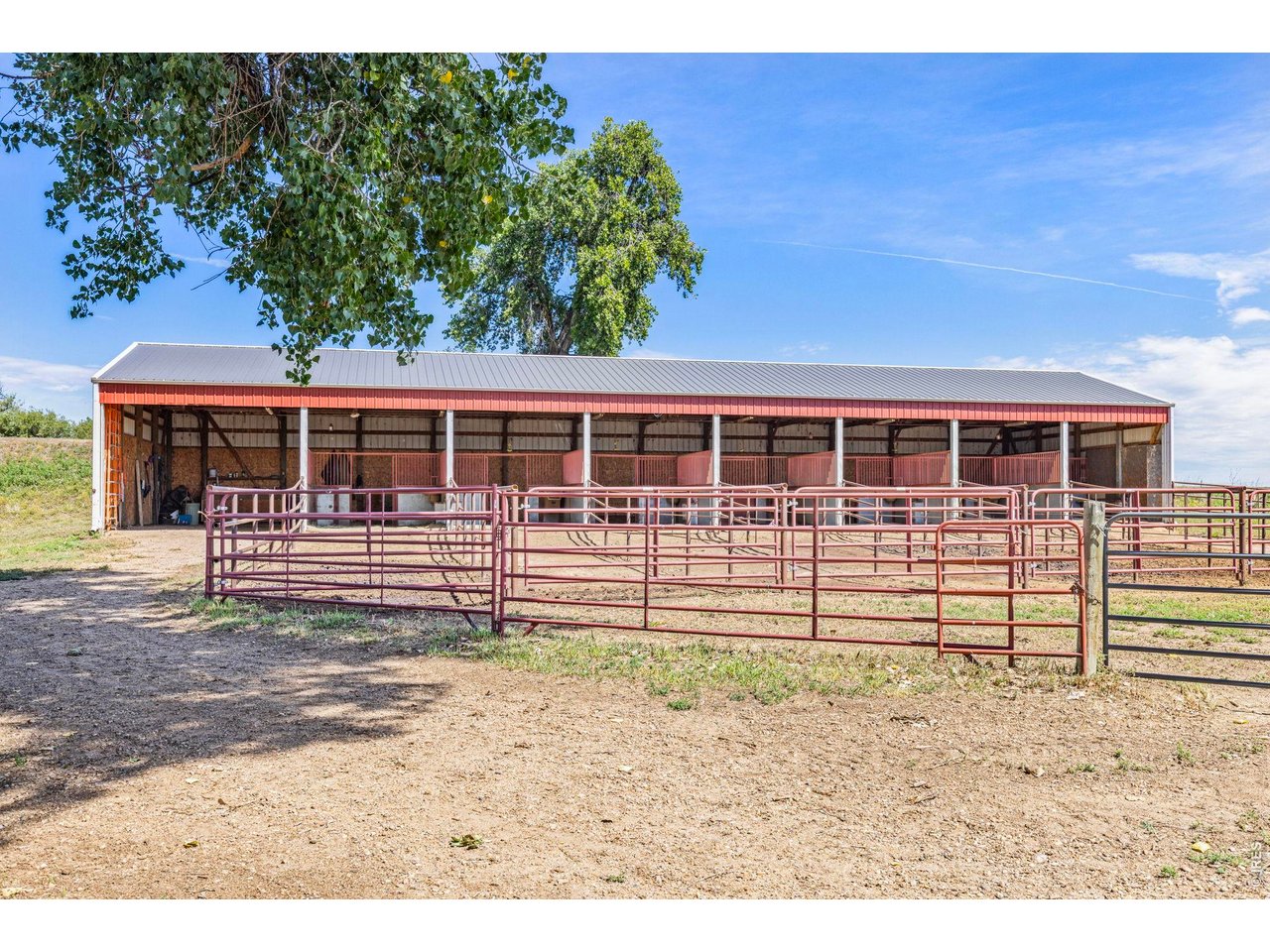Property Photo 25 30' x 100' open-face horse barn with 7 stalls and steel pipe runs.