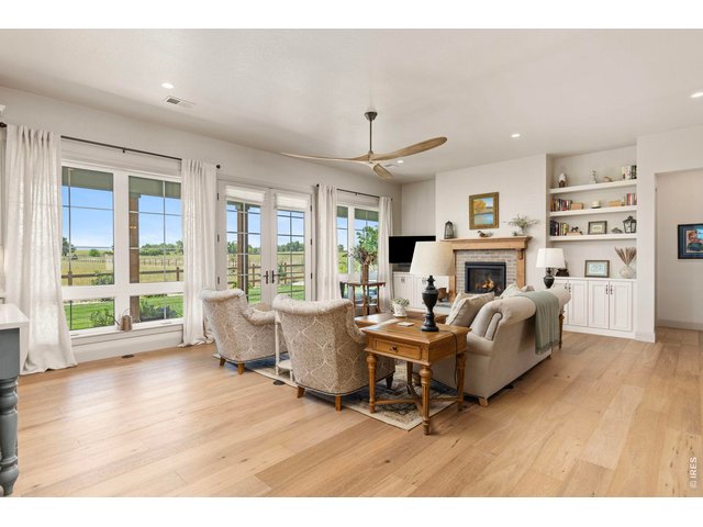 Property Photo 11 Another view of the light-filled living area with fireplace, built-ins and extensive windows.