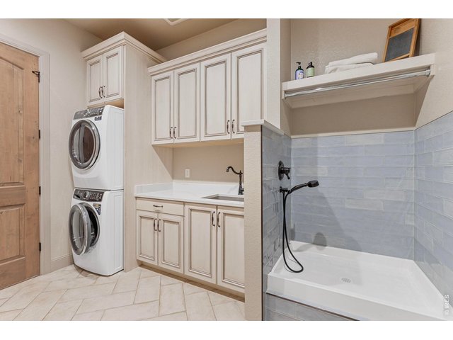 Property Photo 20 Well-appointed laundry/mudroom with extensive cabinetry, utility sink and convenient pet-washing station.