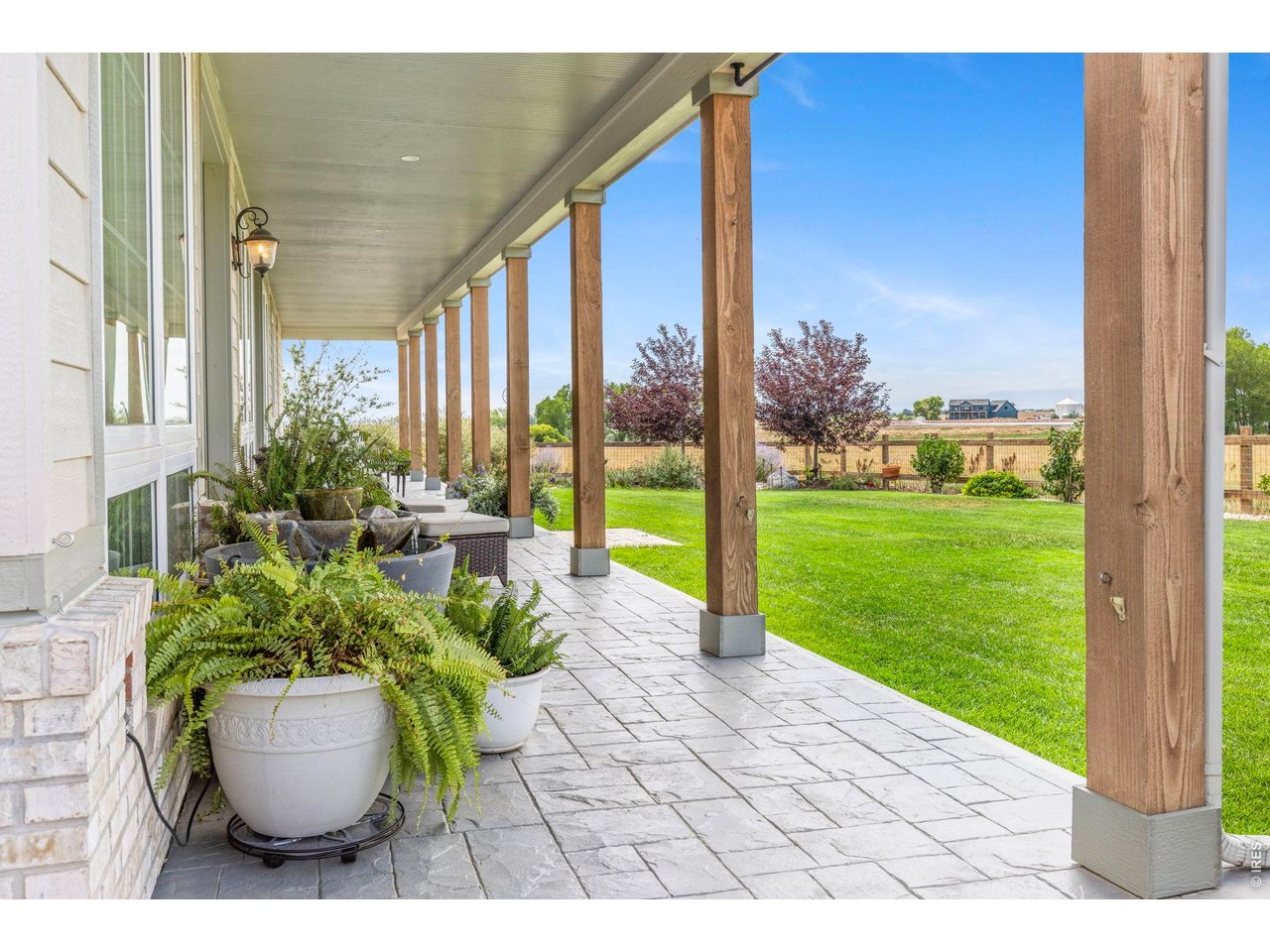 Property Photo 22 Covered outdoor living space overlooks the landscaped yard and surrounding acreage.
