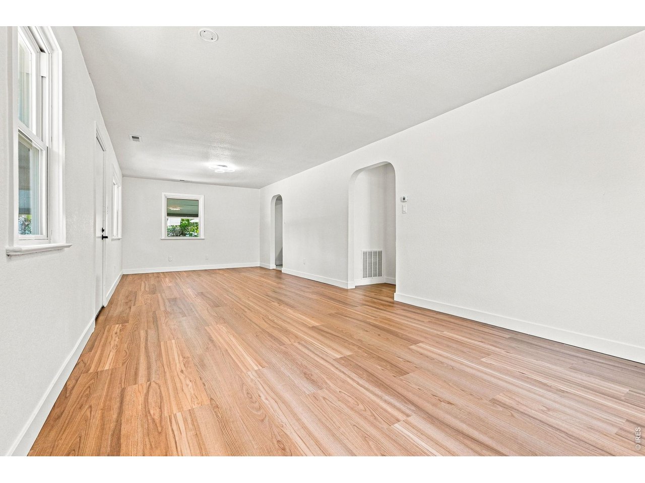 Property Photo 11 Spacious living room and dining area feature laminate wood flooring and plenty of natural light
