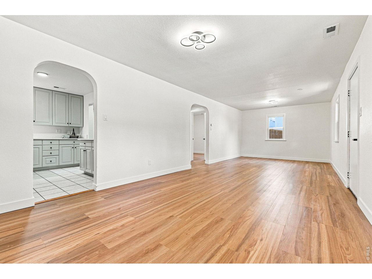 Property Photo 12 Spacious living room and dining area feature laminate wood flooring and plenty of natural light