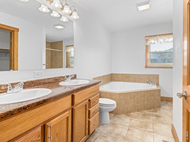 Property Photo 18 Full primary suite bathroom has double sinks and corner soaking tub.