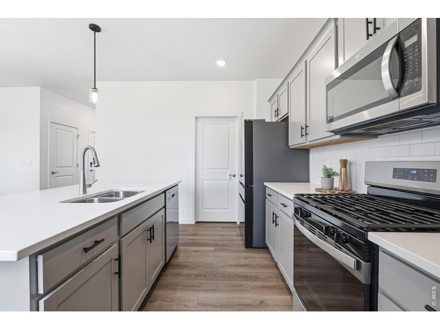 Property Photo 8 Home chef's kitchen featuring a gas range, ample soft-gray cabinetry, and a walk-in pantry just steps away.